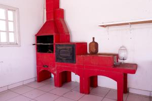 a red stove in the corner of a room at Pousada Hebrom in Bertioga