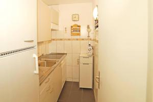a small kitchen with a sink and a refrigerator at Ferienwohnung in Davos platz WEF 2024 in Bolgen