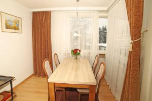a dining room table with chairs and a vase of flowers at Ferienwohnung in Davos platz WEF 2024 in Bolgen