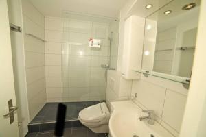 La salle de bains blanche est pourvue de toilettes et d'un lavabo. dans l'établissement Ferienwohnung in Davos platz WEF 2024, à Bolgen