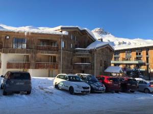 a group of cars parked in a parking lot in front of a building at Appartement Tignes, 5 pièces, 8 personnes - FR-1-641-15 in Tignes