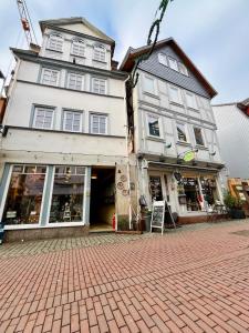 a large white building on a brick street at Gästehaus Keins wie meins in Bad Hersfeld