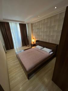 ein Schlafzimmer mit einem großen Bett und Holzboden in der Unterkunft Lost in Tbilisi in Tbilisi City