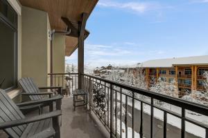 a balcony with two chairs and snow covered trees at Vintage on the Strand by All Seasons Resort Lodging in Park City