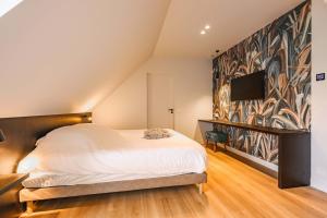 1 dormitorio con 1 cama y TV en la pared en B&B Logie Jolie, en Ypres