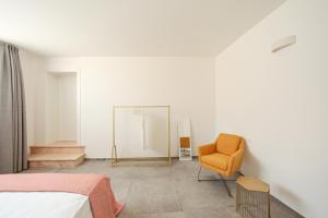 ein Schlafzimmer mit einem Bett, einem Stuhl und einem Spiegel in der Unterkunft Petra - Sud Est Charme in Andrano