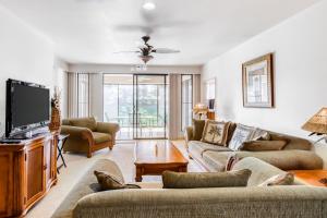 a living room with couches and a flat screen tv at Waikoloa Fairways C119 in Waikoloa Village