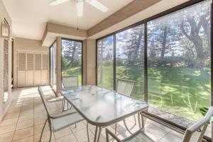 a dining room with a glass table and chairs at Waikoloa Fairways C119 in Waikoloa Village