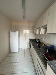 a kitchen with a white refrigerator and a sink at Apto Aconchegante Central! 23 in Toledo