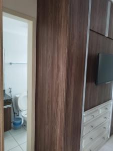a bathroom with a wooden cabinet with a tv on it at @nobrezafiori Apts particular localizado no LacquaDiroma Sem roupas de cama in Caldas Novas