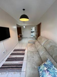 a living room with a couch and a flat screen tv at Apto Aconchegante Central! 23 in Toledo