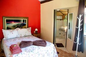 a red bedroom with a bed and a bathroom at Pousada Estância Vip in Cunha