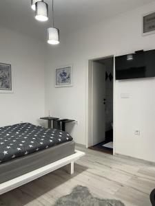 a bedroom with a bed and a table and a mirror at M&M apartments in Tivat