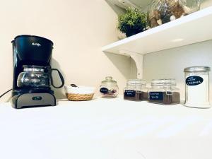 a coffeemaker sitting on a counter next to jars at The Getaway at Palm Dr in Atlanta