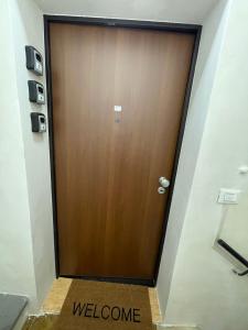 a wooden door in a room with a welcome sign at affittacamere Folignocentro in Foligno