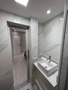 a white bathroom with a sink and a shower at Melhor Localização! Botafogo-URCA in Rio de Janeiro