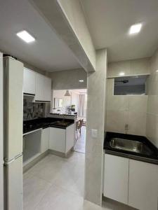 a kitchen with white cabinets and a stainless steel sink at Melhor Localização! Botafogo-URCA in Rio de Janeiro