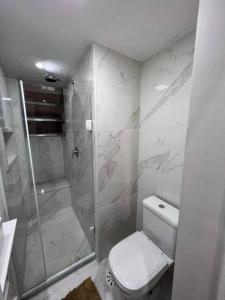 a white bathroom with a toilet and a shower at Melhor Localização! Botafogo-URCA in Rio de Janeiro
