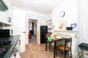 a kitchen with a table and a dining room at Bright Medway studio flat opposite Chatham station in Chatham