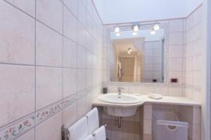 a white bathroom with a sink and a mirror at San Paolo House in Sorrento