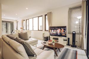 a living room with a couch and a tv at Enjoy Samui Residences（Pause on Samui） in Koh Samui