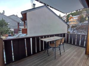 drewniany balkon ze stołem i krzesłem w obiekcie Appartement rénové 3 pièces cabine, 50m des pistes, 8 couchages, balcon SUD, Wifi, TV - FR-1-592-54 w mieście Bolquere Pyrenees 2000