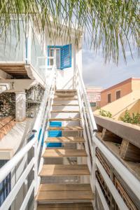 una escalera que conduce a un edificio con detalles azules en CapoSud - Appartamento Sottovento, en Marina di Ragusa
