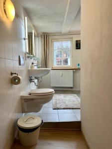 a bathroom with a toilet and a sink and a window at Gästehaus Keins wie meins in Bad Hersfeld