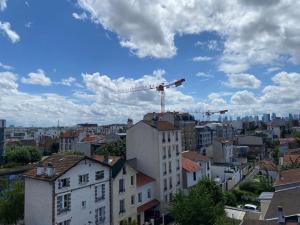 ein Blick auf eine Stadt mit einem Kran am Himmel in der Unterkunft Petit Cosy Aux Portes de Paris, En Face Du M 13 in Asnières-sur-Seine