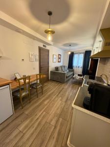 a kitchen and living room with a table and a couch at ATENEO CUENCA Suites con cocina en el casco histórico in Cuenca