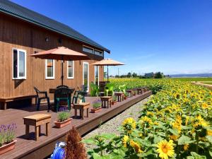 a garden with tables and chairs and sunflowers at Country Cottage Waki Aiai - Vacation STAY 26548v in Sorachi