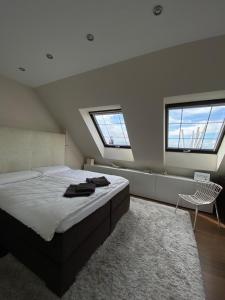 1 dormitorio con 1 cama grande y 2 ventanas en Herper Lounge - Top-Aussicht in Zülpich en Zülpich