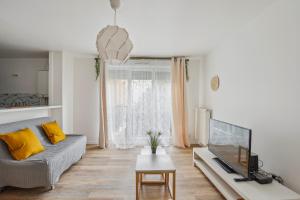 sala de estar con sofá y TV de pantalla plana en Chic and spacious apartment with balcony, en Ivry-sur-Seine
