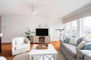 新伦敦Spacious Oceanview Villa Elegant Coastal Escape, Sleeps 22的客厅里有一张沙发和一台电视