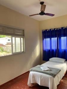 a bedroom with a bed and a ceiling fan at Pousada Família Guarapari in Guarapari