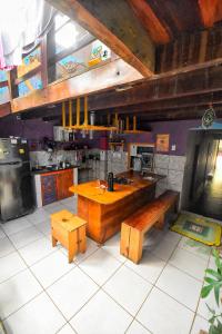 una cocina con mesa de madera y bancos. en Hostel Rota 027 Itacaré, en Itacaré