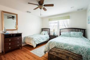 a bedroom with two beds and a ceiling fan at Spacious Oceanview Villa (Sleeps 22) in New London +63 photos