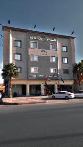 a large building with cars parked in front of it at شقق مساكن السمو المخدومة in Ad Dawādimī