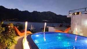 Una piscina con sillas y vista al agua. en DUBAI by luxury Atitlan, en San Pedro La Laguna