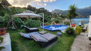 a backyard with a pool and chairs and an umbrella at DUBAI by luxury Atitlan in San Pedro La Laguna
