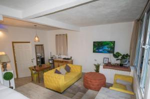 Una sala de estar con un sofá amarillo y una mesa. en DUBAI by luxury Atitlan, en San Pedro La Laguna