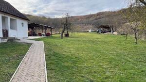 un campo de césped junto a un edificio blanco con un parque en Cabana Nicu Odverem, en Lopadea Nouă 2 fotos más