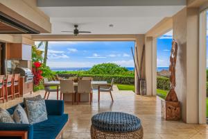 a living room with a blue couch and a table with a view at 2 BR Luxury Oceanview Condo in Kukuiula in Koloa