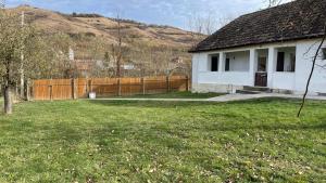 una casa blanca con una valla en un patio en Cabana Nicu Odverem, en Lopadea Nouă