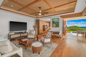 a living room with a couch and a tv at 2 BR Luxury Oceanview Condo in Kukuiula in Koloa