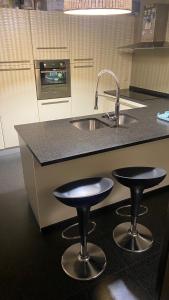 a kitchen with two bar stools and a sink at B&B Jacqmain in Brussels