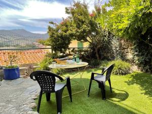 eine Terrasse mit zwei Stühlen und einem Tisch im Gras in der Unterkunft Maison Collioure, 3 pièces, 4 personnes - FR-1-309-368 in Collioure