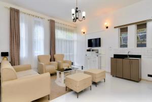 sala de estar con muebles y TV en Edville residence, en Kampala