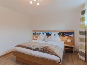 Schlafzimmer mit einem Bett mit weißer Bettwäsche und Kissen in der Unterkunft Residenz Gamper in Brixen im Thale