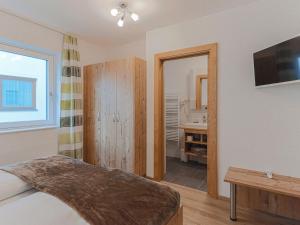 a bedroom with a bed and a bathroom with a sink at Residenz Gamper in Brixen im Thale